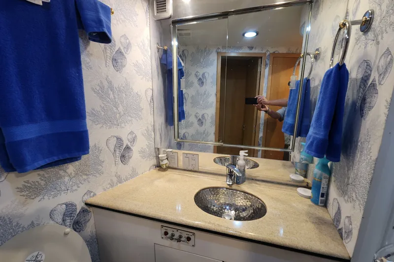 Slide: The Image of Bathroom interior of 1999 Hatteras 65 Convertible yacht with blue towels and seashell wallpaper. - 26