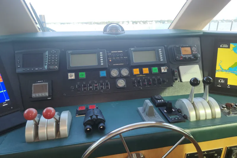 Slide: The Image of Control panel of a 1999 Hatteras 65 Convertible yacht with navigation equipment and steering wheel. - 45