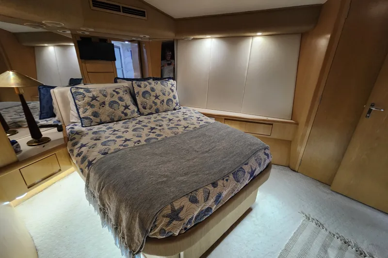 Slide: The Image of Luxurious bedroom interior of 1999 Hatteras 65 Convertible yacht with elegant bedding and lighting. - 17