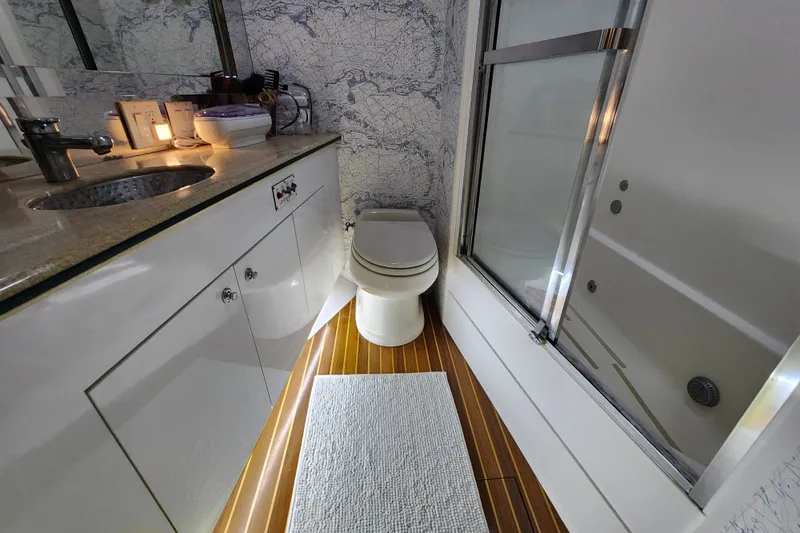 Slide: The Image of Luxurious bathroom in 1999 Hatteras 65 Convertible yacht with modern fixtures and elegant design. - 21