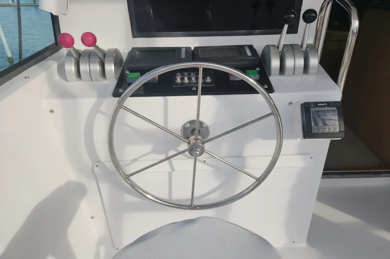 Slide: The Image of Steering wheel and controls of a 1999 Hatteras 65 Convertible yacht. - 52