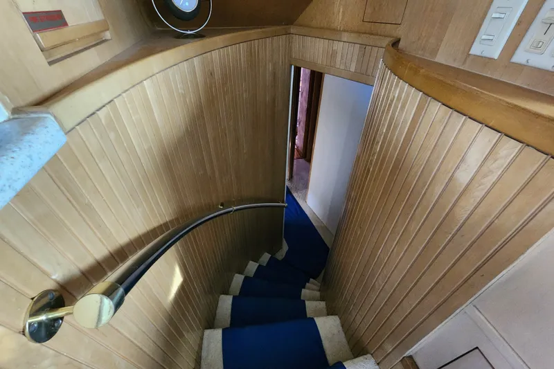 Slide: The Image of Interior staircase of 1999 Hatteras 65 Convertible yacht with wooden paneling and blue carpet. - 15