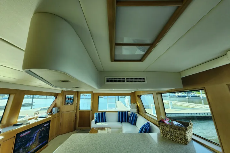 Slide: The Image of Luxurious interior of 1999 Hatteras 65 Convertible yacht with elegant seating and large windows. - 14