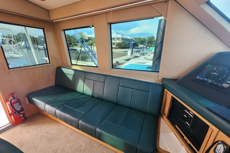 Slide: The Image of Interior of 1999 Hatteras 65 Convertible yacht with green seating and navigation equipment. - 43