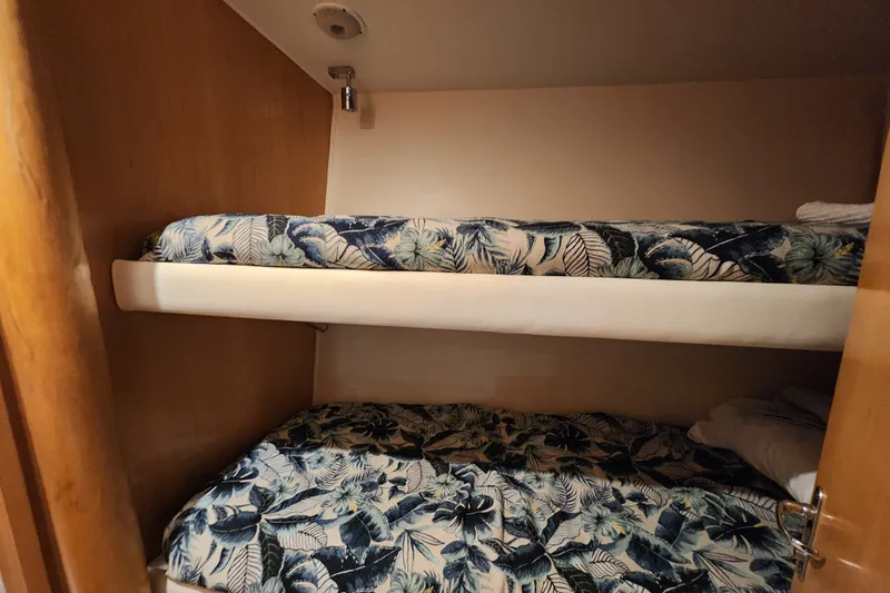 Slide: The Image of Bunk beds with floral bedding in a 1999 Hatteras 65 Convertible yacht cabin. - 31