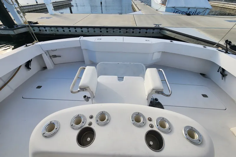 Slide: The Image of 1999 Hatteras 65 Convertible yacht cockpit with fishing rod holders at marina. - 59