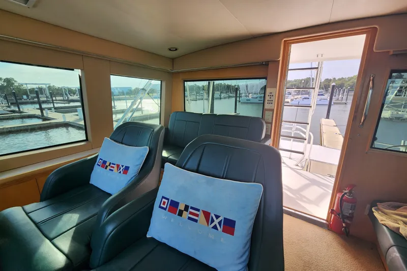 Slide: The Image of Interior of 1999 Hatteras 65 Convertible yacht with plush seating and marina view. - 41