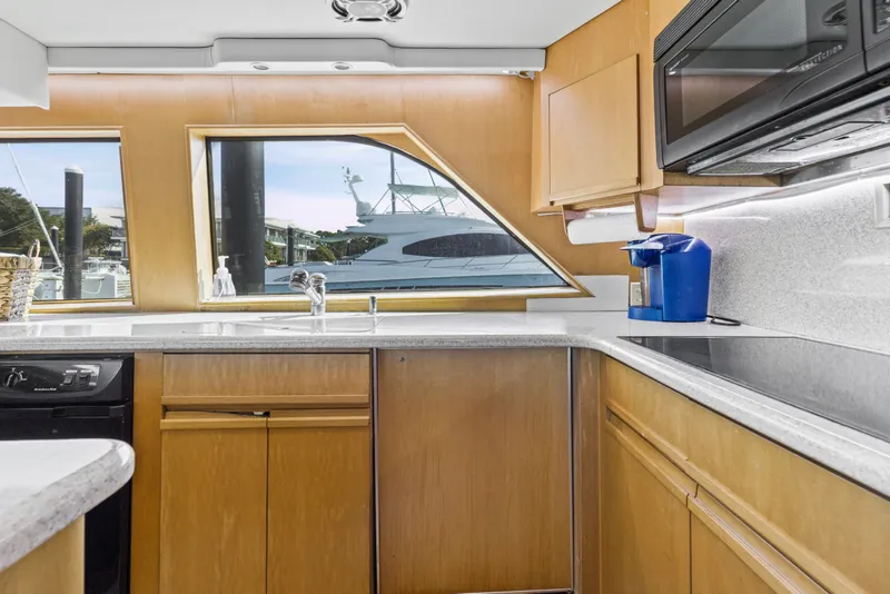 Slide: The Image of Modern kitchen interior of 1999 Hatteras 65 Convertible yacht with sleek countertops and appliances. - 101