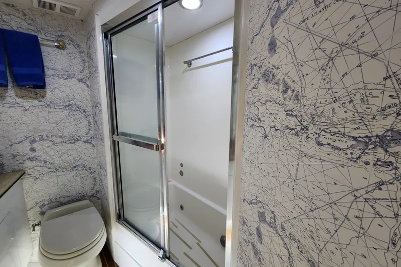 Slide: The Image of Bathroom in 1999 Hatteras 65 Convertible yacht with nautical map wallpaper and modern shower. - 19