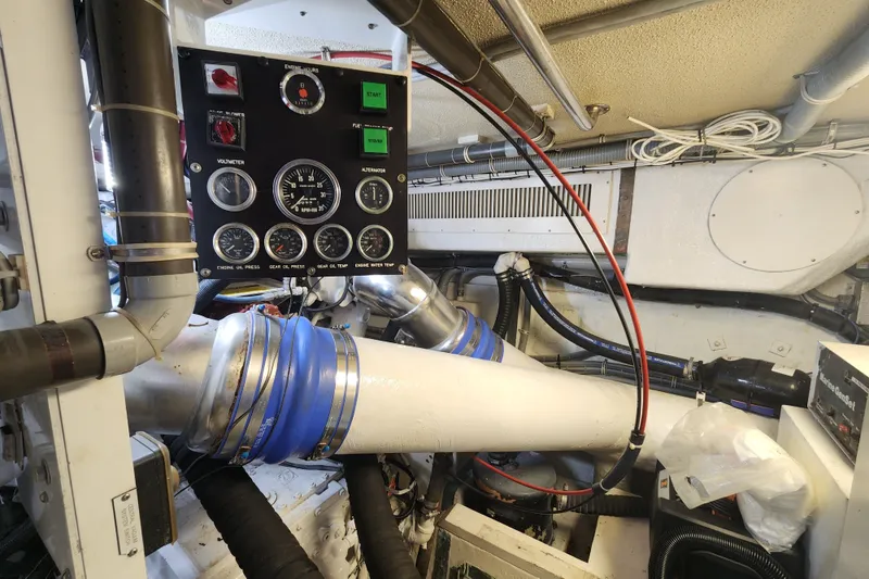Slide: The Image of Engine room of a 1999 Hatteras 65 Convertible yacht with control panel and exhaust system. - 80