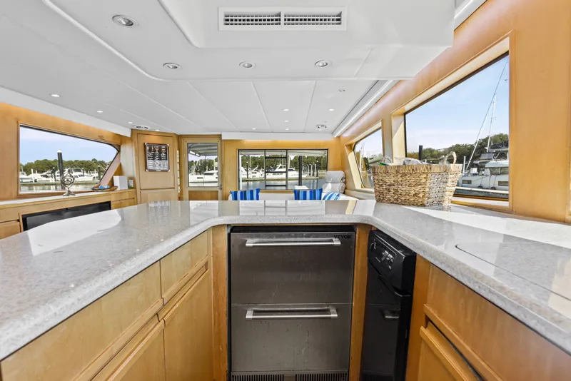 Slide: The Image of Luxurious interior of 1999 Hatteras 65 Convertible yacht with modern kitchen and large windows. - 102