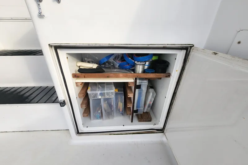 Slide: The Image of Storage compartment on a 1999 Hatteras 65 Convertible boat, organized with tools and supplies. - 70