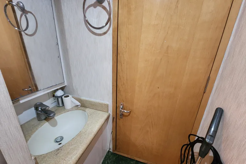 Slide: The Image of Bathroom interior of 1999 Hatteras 65 Convertible yacht with sink and wooden door. - 37