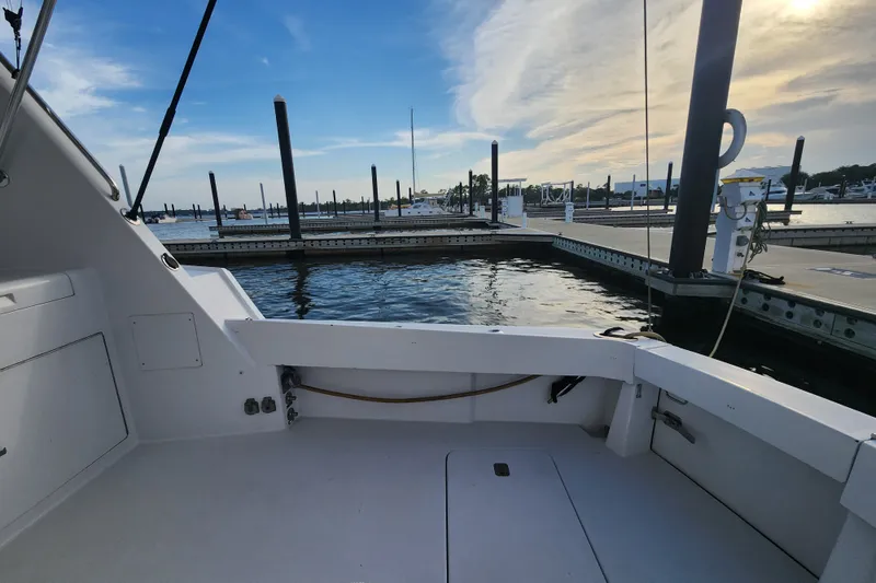 Slide: The Image of 1999 Hatteras 65 Convertible yacht docked at marina under blue sky. - 67