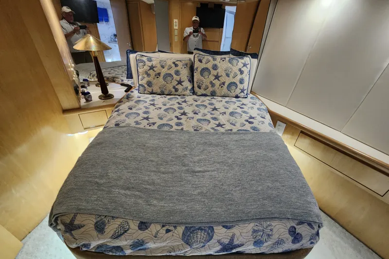 Slide: The Image of Luxurious bedroom interior of 1999 Hatteras 65 Convertible yacht with nautical-themed bedding. - 16