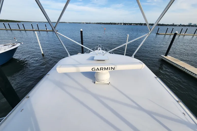 Slide: The Image of 1999 Hatteras 65 Convertible yacht with Garmin radar, docked by calm waters. - 55