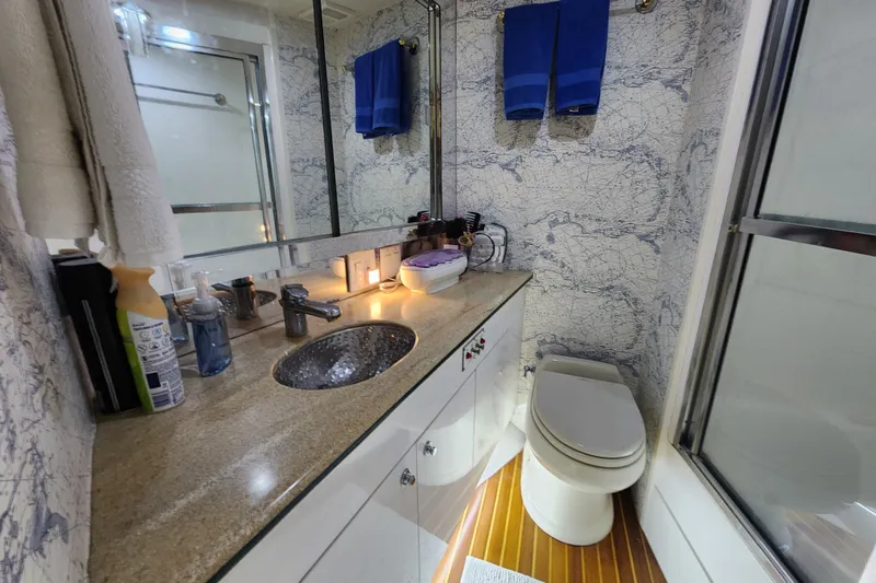 Slide: The Image of Luxurious bathroom in 1999 Hatteras 65 Convertible yacht with elegant fixtures and nautical decor. - 20