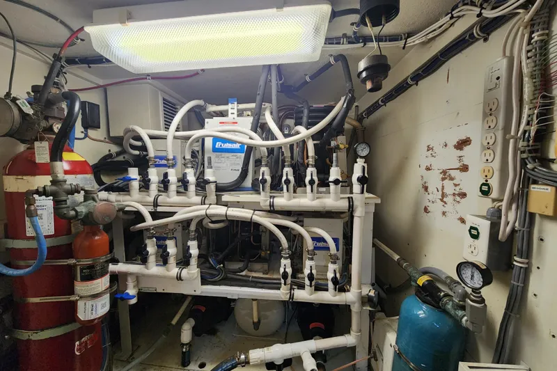 Slide: The Image of Engine room of a 1999 Hatteras 65 Convertible yacht with complex piping and equipment. - 72