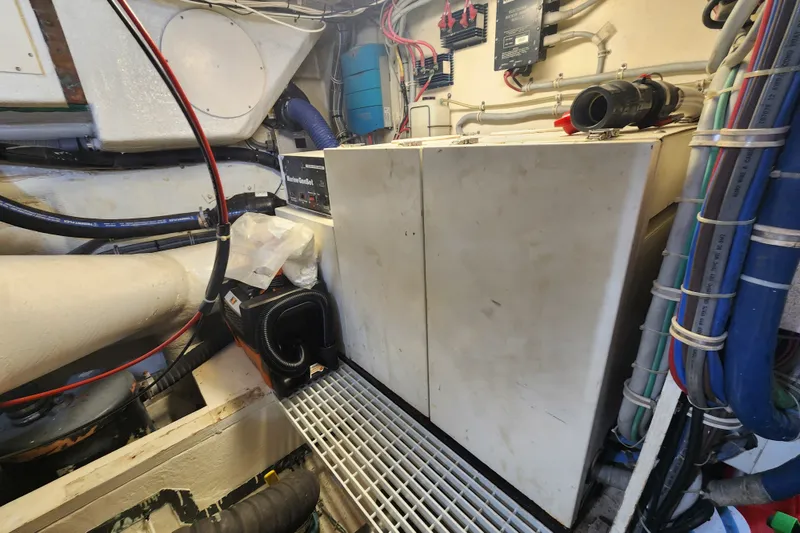 Slide: The Image of Engine room of a 1999 Hatteras 65 Convertible yacht with visible machinery and wiring. - 79