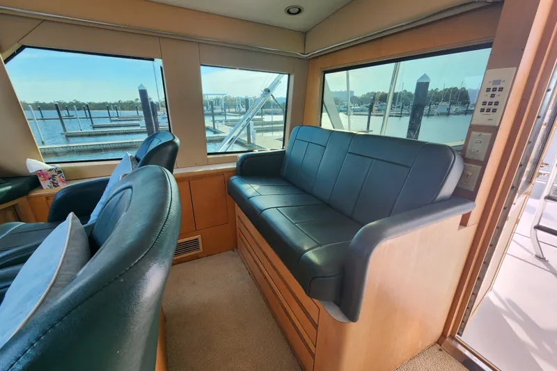 Slide: The Image of Interior of 1999 Hatteras 65 Convertible yacht with leather seating and marina view. - 42
