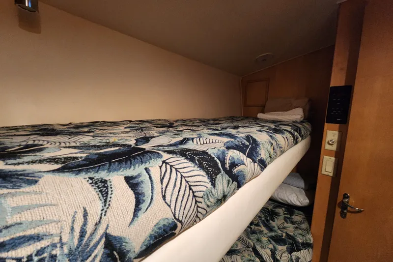 Slide: The Image of Bunk beds with tropical bedding in a 1999 Hatteras 65 Convertible yacht cabin. - 29