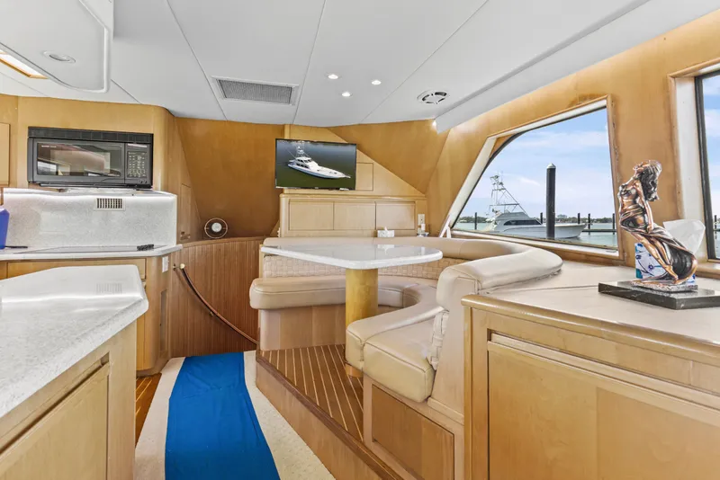 Slide: The Image of Luxurious interior of a 1999 Hatteras 65 Convertible yacht with elegant seating and decor. - 104