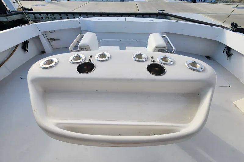 Slide: The Image of 1999 Hatteras 65 Convertible yacht cockpit with rod holders and seating area. - 58