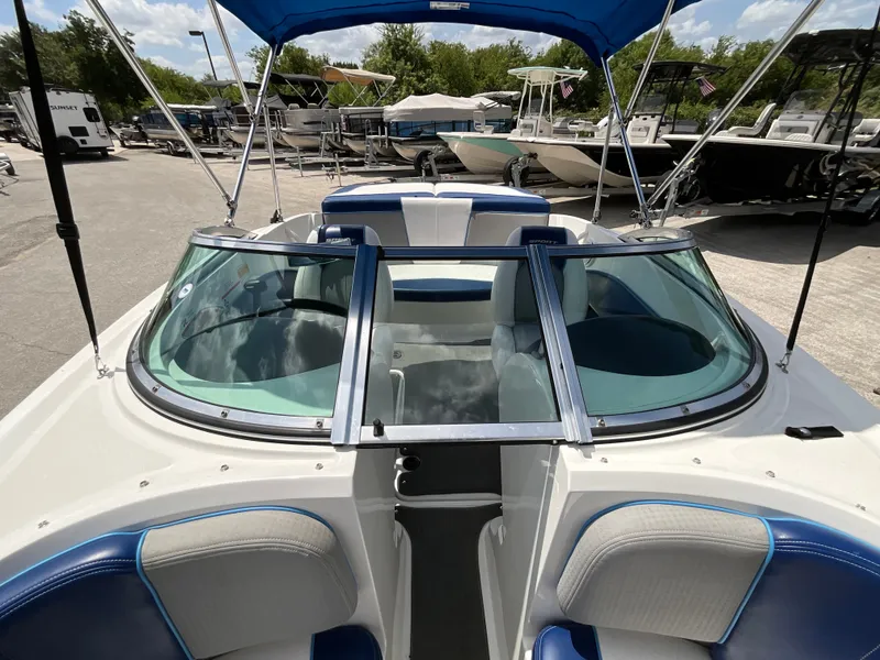 Slide: The Image of A 2011 Sea Ray 185 Sport with blue and white seating and a blue sunshade. - 15