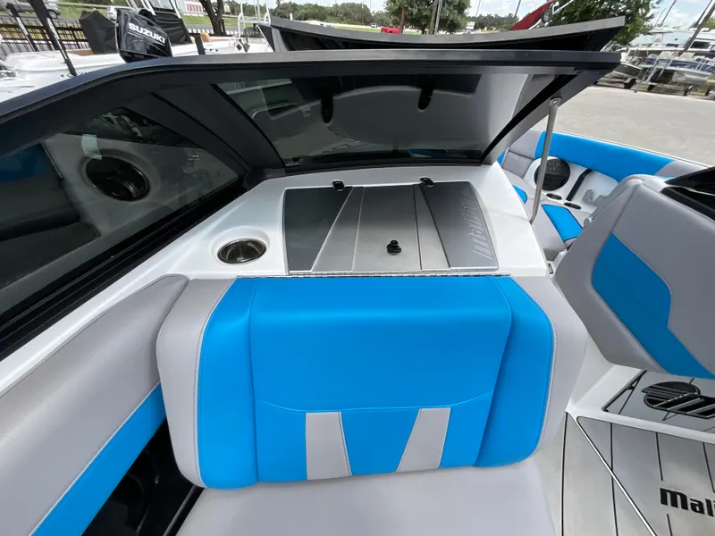 Slide: The Image of The image shows the interior of a 2022 Malibu 23LVS boat with blue and gray seating. - 24