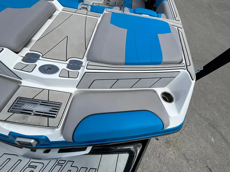 Slide: The Image of The image shows the rear of a 2022 Malibu 23LVS boat with blue and gray upholstery. - 8