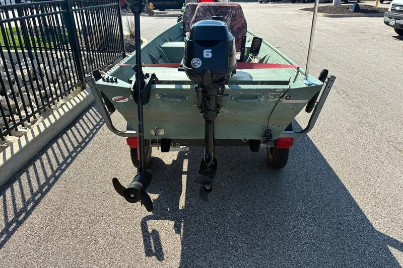 Slide: The Image of 1999 Jon Boat 1436 with motor, parked on pavement, rear view. - 3
