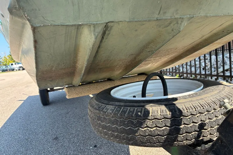 Slide: The Image of 1999 Jon Boat 1436 on trailer, showing underside and tire detail. - 8