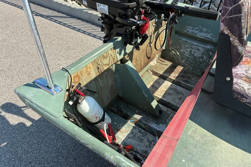 Slide: The Image of 1999 Jon Boat 1436 interior with motor, fire extinguisher, and seat. - 6