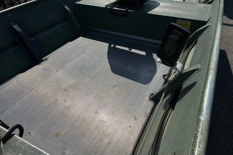 Slide: The Image of 1999 Jon Boat 1436 interior with metal flooring and mounted equipment. - 4