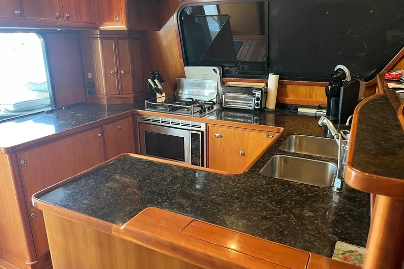 Slide: The Image of Luxurious kitchen in 2003 Pachoud Yachts Power Cat with modern appliances and wooden cabinetry. - 13