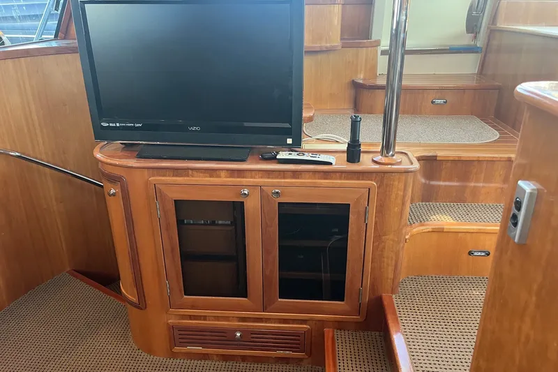 Slide: The Image of Interior of 2003 Pachoud Yachts Power Cat featuring a TV and wooden cabinetry. - 21