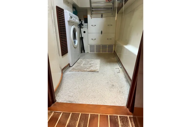 Slide: The Image of Laundry area inside 2003 Pachoud Yachts Power Cat, featuring washer and storage cabinets. - 32