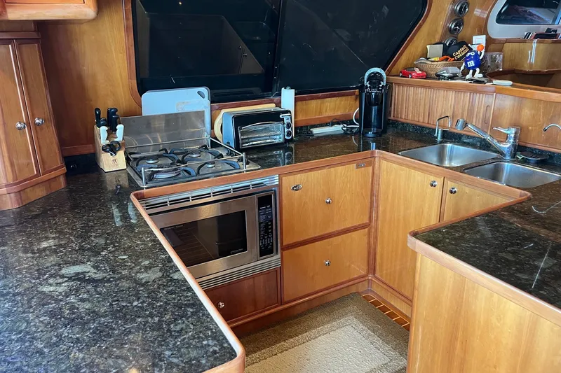 Slide: The Image of Luxurious 2003 Pachoud Yachts Power Cat kitchen with modern appliances and wooden cabinetry. - 14