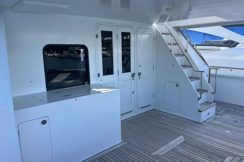 Slide: The Image of 2003 Pachoud Yachts Power Cat interior with sleek white design and wooden flooring. - 9