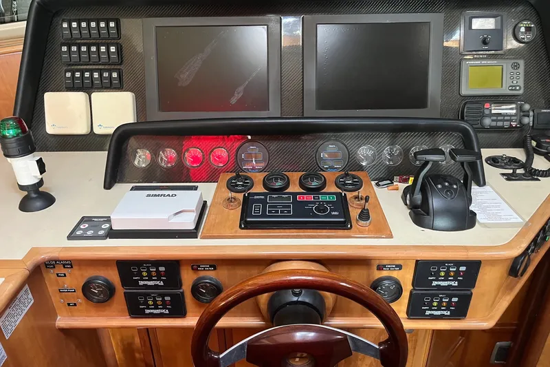 Slide: The Image of Control panel of a 2003 Pachoud Yachts Power Cat with navigation instruments and steering wheel. - 17