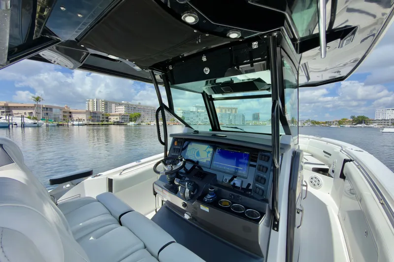 Slide: The Image of 2021 Blackfin 332 CC boat interior with advanced navigation system, docked in a scenic marina. - 22