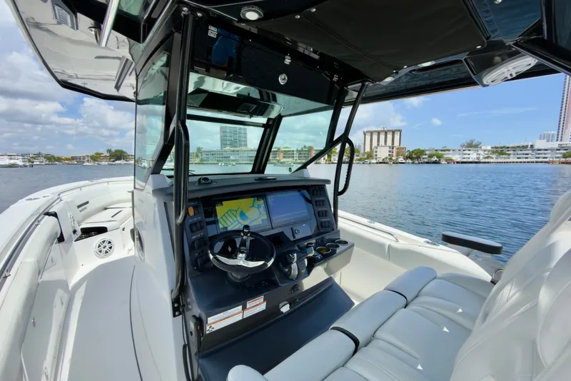Slide: The Image of 2021 Blackfin 332 CC boat interior with modern dashboard and waterfront view. - 21