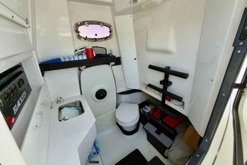 Slide: The Image of Interior of 2021 Blackfin 332 CC boat featuring a compact bathroom setup. - 30