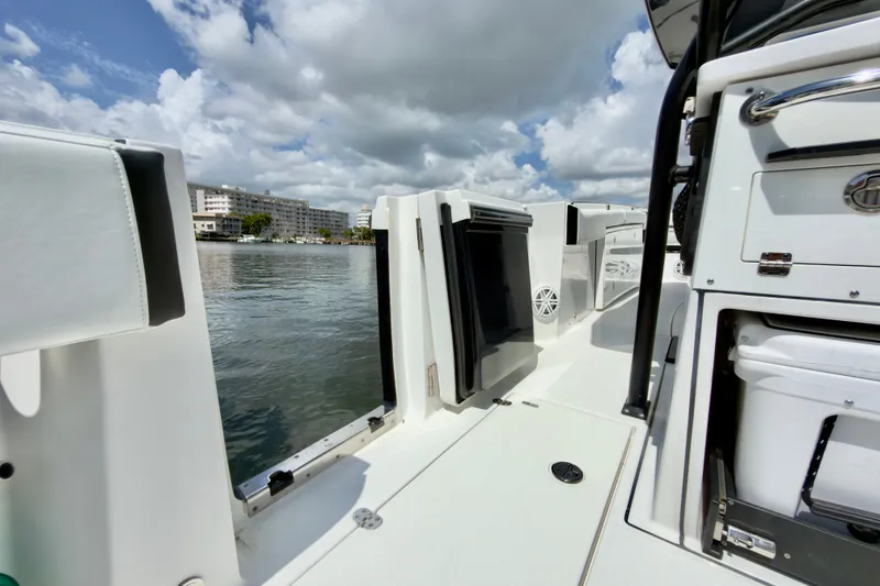 Slide: The Image of 2021 Blackfin 332 CC boat interior with sleek design, docked by waterfront buildings. - 19