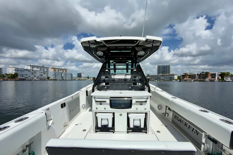 Slide: The Image of 2021 Blackfin 332 CC boat on calm water with cityscape background under cloudy sky. - 14
