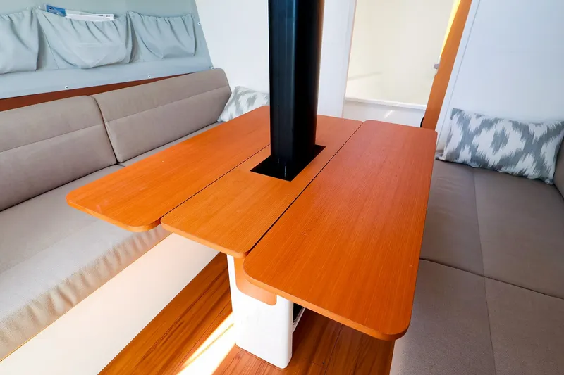 Slide: The Image of Interior of 2023 J Boats J/99 sailboat with wooden table and cushioned seating. - 40