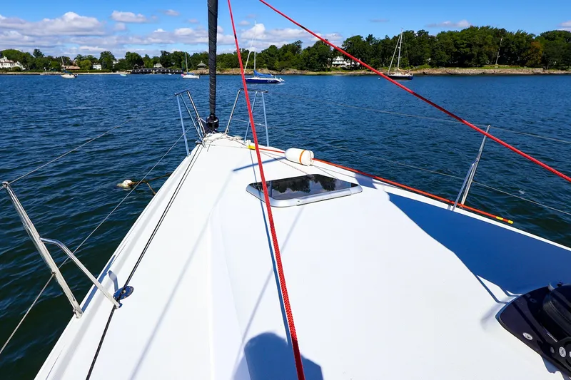 Slide: The Image of Sailing on a 2023 J Boats J/99 yacht, calm waters, clear sky, scenic shoreline. - 18