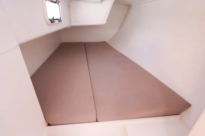 Slide: The Image of 2023 J Boats J/99 interior cabin with beige cushions and a small window. - 57