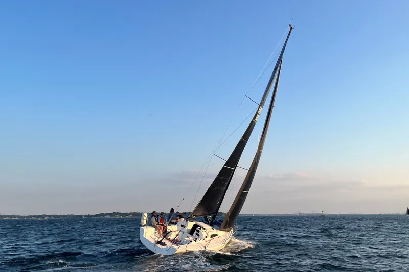 Slide: The Image of 2023 J Boats J/99 sailing on open water under clear blue skies. - 12