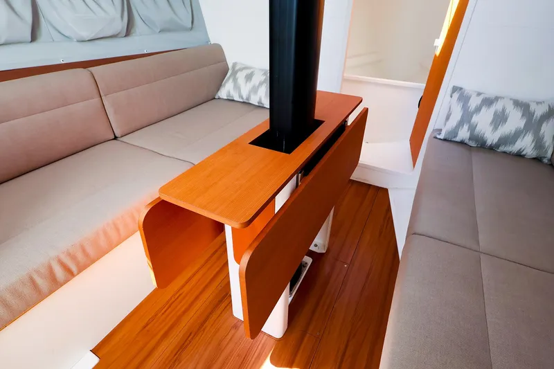 Slide: The Image of Interior of 2023 J Boats J/99 sailboat with wooden table and beige seating. - 41